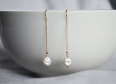 These beautiful freshwater pearl earrings are perfect for a graduation, Mother's Day, a wedding, birthday, anniversary, graduation or for any occasion. The genuine freshwater pearl earring pendants a gorgeous white shade and each pearl are unique and naturally shaped.  The approximate size of the pearls is 8x13mm (each pearl has a slightly different size). The gold plated earring threads are 45 mm. These earrings are so dainty and very pretty - perfect for everyday wear. These pieces will ship b Elegant Earrings For Anniversary And Mother's Day, Elegant Pearl Drop Earrings For Mother's Day, Minimalist Pearl Earrings For Anniversary, Elegant Pearl Earrings For Wedding And Mother's Day, Formal Pearl Earrings For Mother's Day, Gift Pearl Chain Earrings, Minimalist Pearl Earrings With Pearl Chain For Anniversary, Elegant Dangle Pearl Earrings For Mother's Day, Minimalist Pearl Chain Earrings For Anniversary