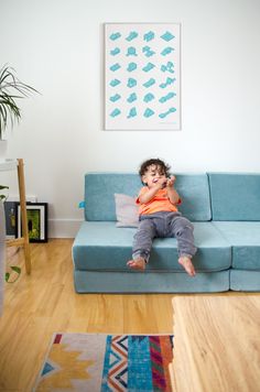 a young boy sitting on top of a blue couch