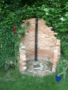 a brick oven in the middle of a garden