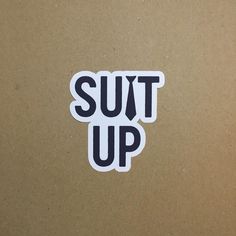 a sticker that says suit up on the side of a brown cardboard box with black lettering