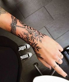 a woman's arm with tattoos on it and her hand in the middle of the photo