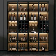 the shelves are filled with many different types of wine bottles and glasses on display in an empty room