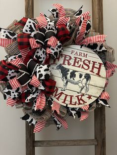 a red and black cow print wreath with the words farm fresh milk written on it