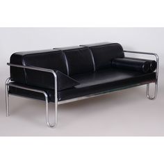 a black leather couch with chrome legs on a white background