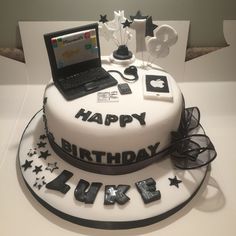 a birthday cake with a laptop on top and stars around the edges that spell happy birthday