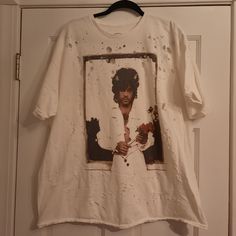 Washed Soft With Distressed Details, This Cotton T-Shirt Dress Is Topped With A Prince Photo Graphic At The Front. Cut In An Oversized Fit With Dropped Short Sleeves And Topped With A Ribbed Crew Neck. Content + Care. 100% Cotton Machine Wash Imported Size + Fit. Item Shown Is Size Small/Medium \T Measurements Taken From Size Small/Medium Chest: 51" Length: 28" New And Unused Without Tag Line Through Label To Prevent Store Returns From A Pet And Smoke Free Environment Spring Streetwear Distressed T-shirt, Oversized Distressed White T-shirt, White Distressed T-shirt For Streetwear, Prince T Shirt, Urban Drop Shoulder T-shirt With Text Print, Urban Outfitters Shirts, White Harajuku T-shirt With Graffiti Print, Oversized Urban T-shirt With Graffiti Print, A Prince