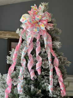 a decorated christmas tree with pink and white bows