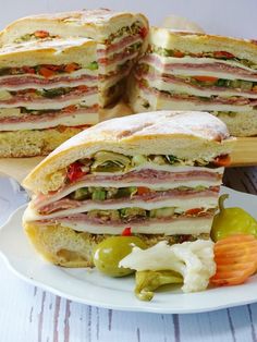 a cut in half sandwich sitting on top of a white plate next to some vegetables