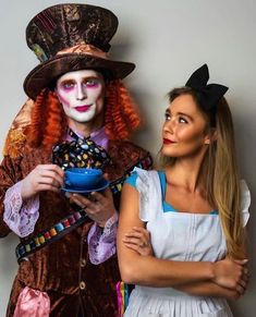 two people dressed up in costumes posing for a photo with one holding a bowl and the other wearing a top hat