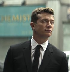 a man in a suit and tie looking off into the distance