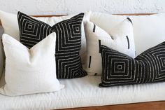 three black and white pillows sitting on top of a couch