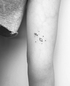 a woman's arm with small space tattoos on the left side of her leg