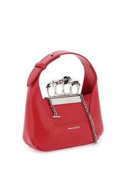 The Alexander McQueen Welsh Red smooth calfskin leather Jewelled Hobo featuring an antique silver-finished handle adorned with Swarovski-encrusted rings. The unique silhouette of the Jewelled Hobo is inspired by the faceted stone that sits on the Knuckle, and features leather panels that are cut and re-assembled together. This bag can be worn either hand-held or over the shoulder or across the body with its detachable chain. Alexander Mcqueen Handbags, Alexander Mcqueen Oversized Sneaker, Alexander Mcqueen Bag, Platform Combat Boots, Leather Jewels, Leather Patches, Roberto Cavalli, Hobo Bag, Magnetic Closure