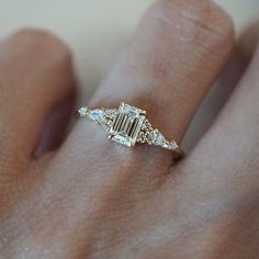 a woman's hand with a diamond ring on it