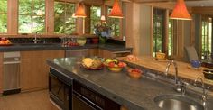 a kitchen filled with lots of counter top space next to a sink and stovetop oven