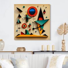 an abstract painting hangs on the wall above a white couch with pillows and decorative vases