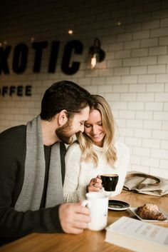 a man and woman sitting at a table with coffee