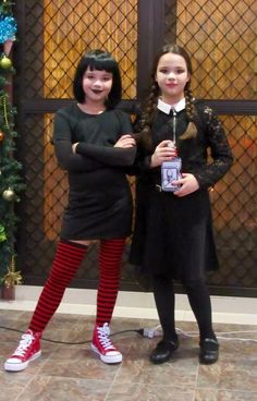 two girls dressed in black and red posing for the camera