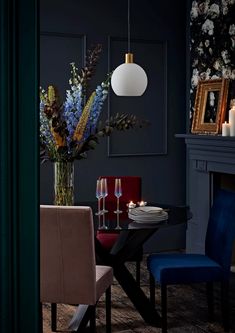 a dining room table with two chairs and a vase filled with flowers