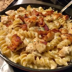 a pan filled with pasta covered in chicken and cheese