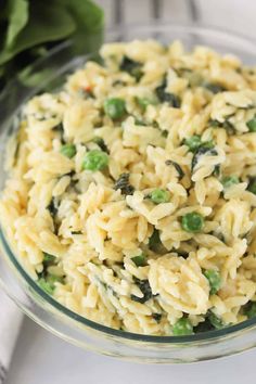 a glass bowl filled with pasta and peas