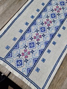 a blue and white rug sitting on top of a wooden table next to a bench