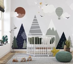 a baby's room with a crib and wallpaper that has trees on it