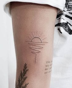 a woman's arm with a tattoo on it that has an image of the sun