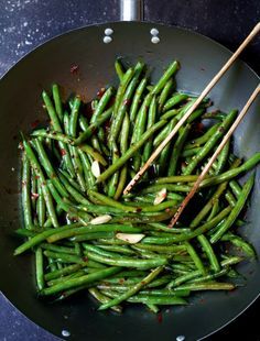 green beans in a frying pan with chopsticks