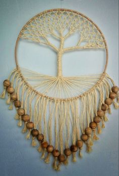 a tree of life made out of macrame and wood beads is hanging on the wall