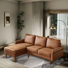 a living room with a couch, chair and lamp on the floor in front of a window