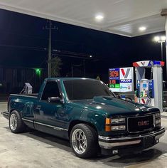 a truck parked in front of a gas station at night with no one around it