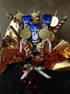 a bouquet of candy and candies in a glass vase with gold foil wrappers