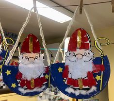 two santa claus ornaments hanging from strings in a store