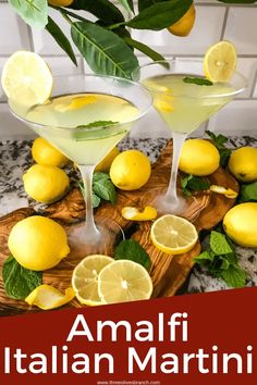 two martini glasses with lemons and mint on a cutting board