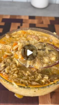 a glass bowl filled with soup on top of a wooden table