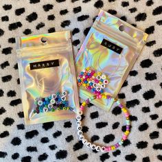 two bags filled with beads sitting on top of a blanket