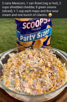 an image of a bowl of party size corn salad on a table with a bag of scoops in the background