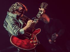 a man playing an electric guitar on stage