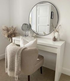 a white desk with a mirror and chair