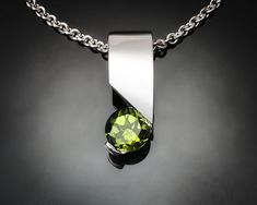 "Peridot Necklace - Argentium Silver - 3460 - Argentium Chain Included Make a statement with this modern artisan crafted pendant. ( IMPORTANT - PLEASE READ 1. AND 2 BELOW ) 1.) INCLUDED IN THE PRICE IS AN ARGENTIUM SILVER CHAIN APPROPRIATE FOR THE PENDANT CHOSEN. YOU CAN CHOOSE FROM 16\", 18\" OR 20\" LENGTH AT CHECKOUT. 2.) PLEASE LOOK AT THE MEASUREMENTS CAREFULLY. SOME PHOTOS HAVE BEEN ENLARGED TO SHOW DETAIL, WHILE OTHERS HAVE BEEN MINIMIZED TO FIT THE FRAME. ACTUAL SIZE CANNOT BE DETERMINED Swiss Blue Topaz Necklace, Aqua Pendant, London Blue Topaz Necklace, December Birthstone Jewelry, Yucca Valley, Blue Topaz Necklace, Peridot Necklace, Aquamarine Pendant, Aquamarine Necklace