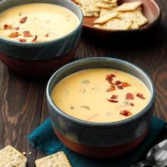 three bowls of soup with crackers on the side