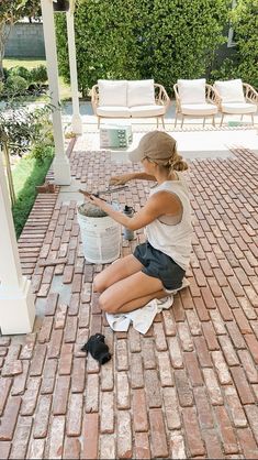 a woman sitting on the ground next to a bucket