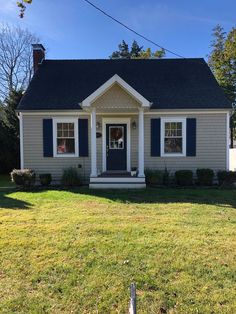 a small gray house with blue shutters