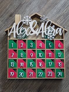 a wooden house shaped calendar with snowflakes on it and the word ale & algon written in white