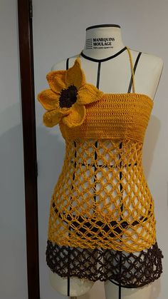 a mannequin wearing a yellow top with a sunflower on it's back