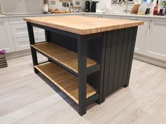 a kitchen island made out of wood and metal with shelves on each side for storage