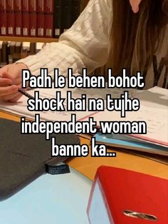 a woman sitting at a desk in front of books and papers with the words padh i