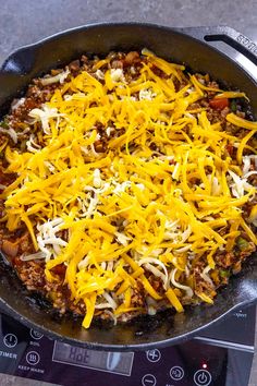 a skillet filled with cheese and meat on top of a stove burner oven