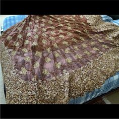 a bed with a brown and gold bedspread on it